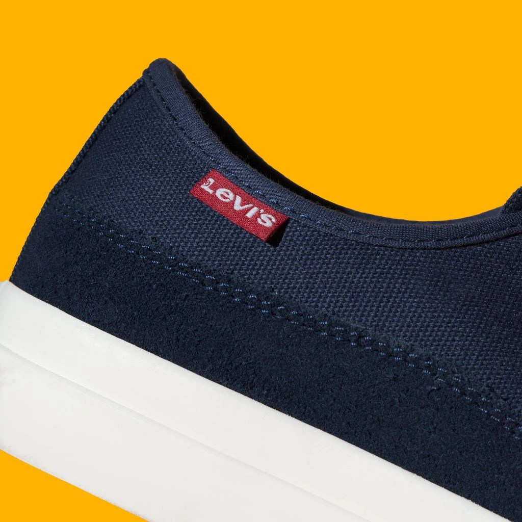 Macro photograph of three rows of even stitching on a sneaker toe panel.